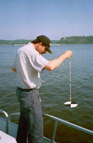 Researcher conducting water quality assessment from a boat